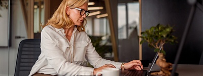 Woman with serious expression and glasses on computer