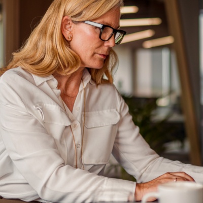 Woman with serious expression and glasses on computer