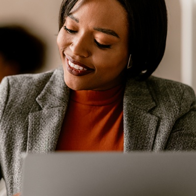 woman-writing-at-desk-in-front-of-laptop