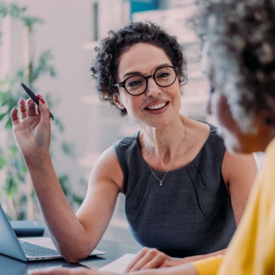 Women in a business meeting with text to the left: Five ways contract intelligence accelerates M&A.