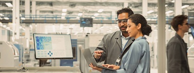 Two colleagues in lab working on laptop
